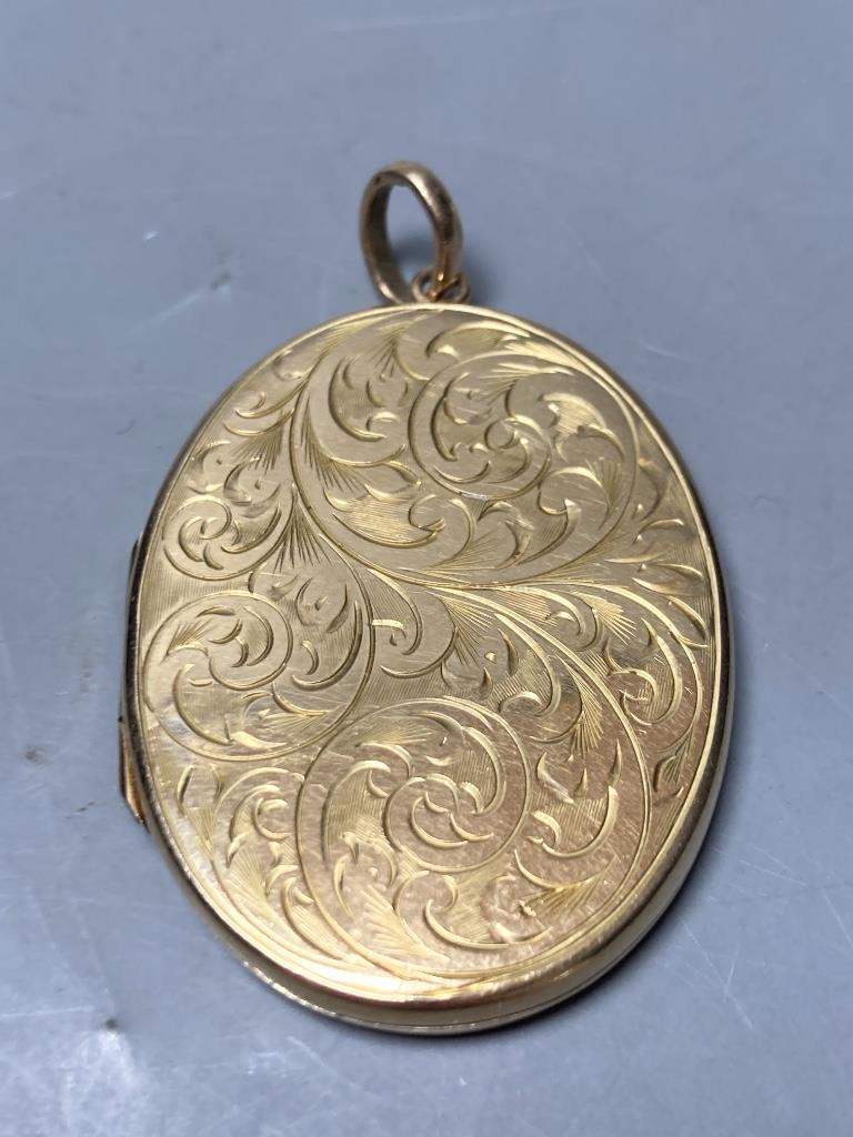 A 1960's engraved 9ct gold mounted oval pendant locket